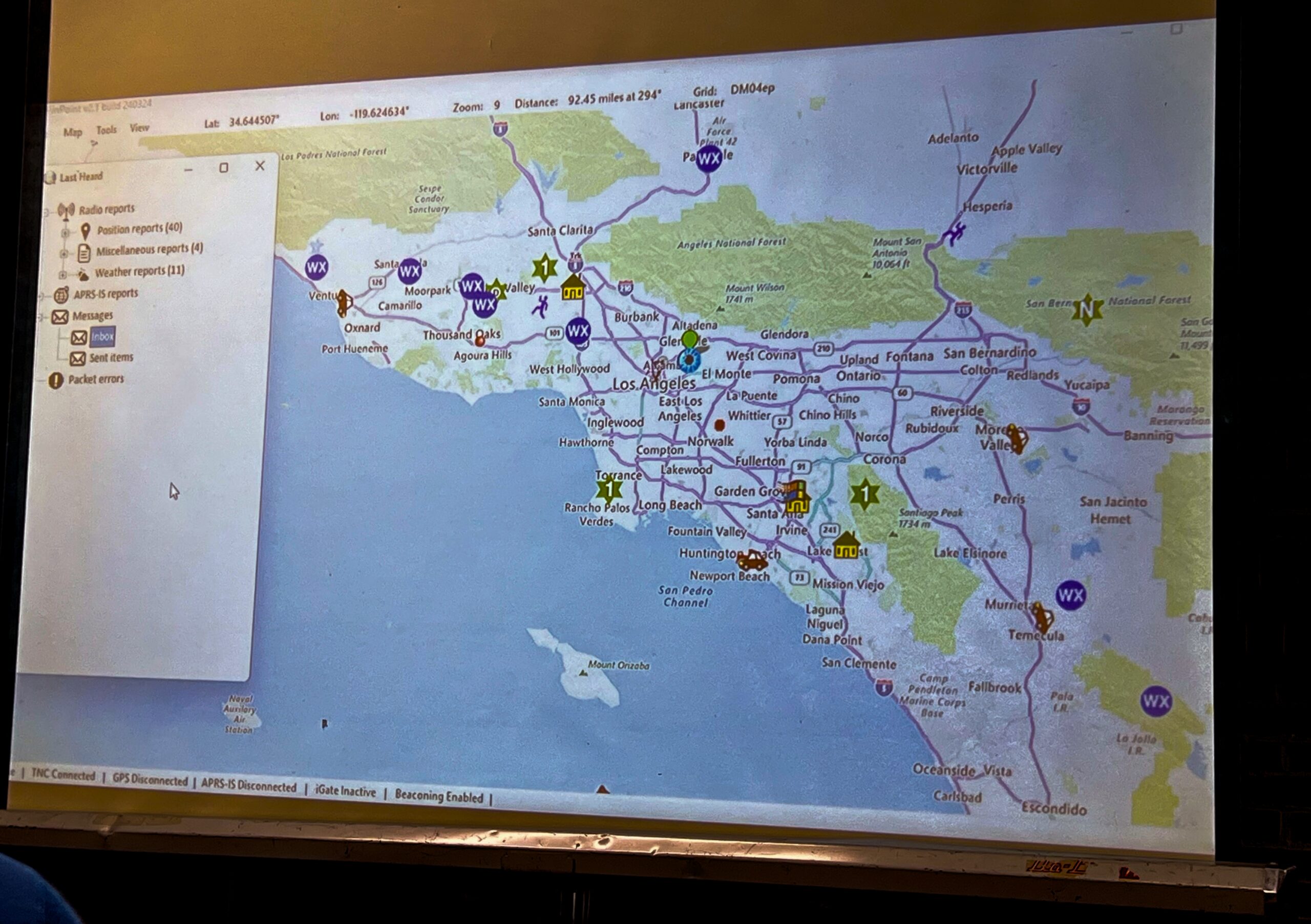 A screen onto which a projector displays the Windows program PinPoint APRS. There is a map of Southern California.